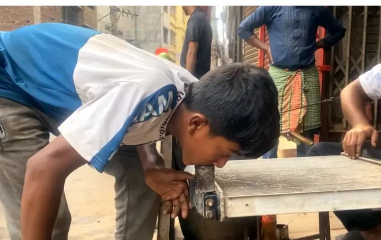 A child at work in an urban auto garage, from the field observation behind the short film.